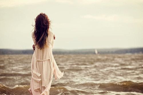 Hình ảnh người phụ nữ xinh đẹp đứng trước biển với tâm trạng buồn